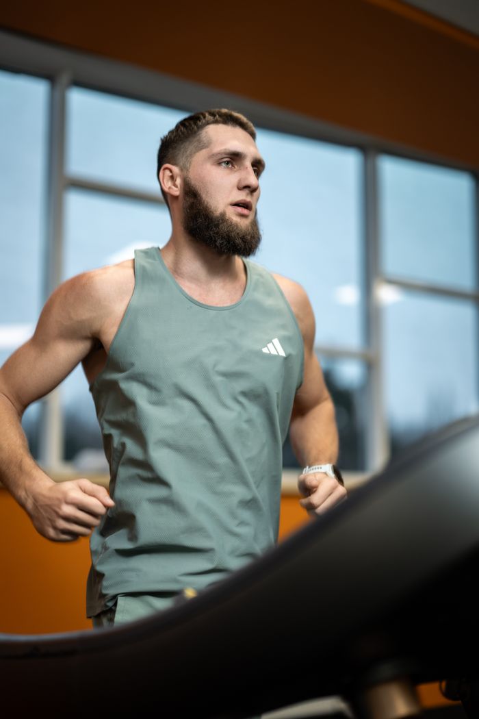 services-02 Athletic bearded man running on a treadmill, focused on fitness goals.